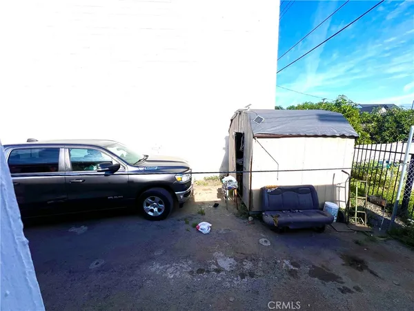 a view of a backyard with chair and potted plants
