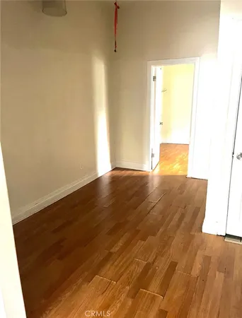 a view of empty room with wooden floor and cabinet