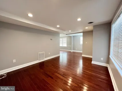 a view of empty room with wooden floor and windows