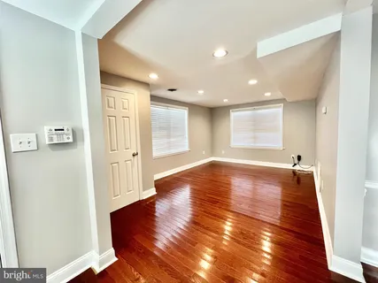 a view of empty room with wooden floor