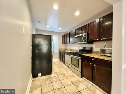 a kitchen with stainless steel appliances granite countertop a refrigerator and a stove top oven