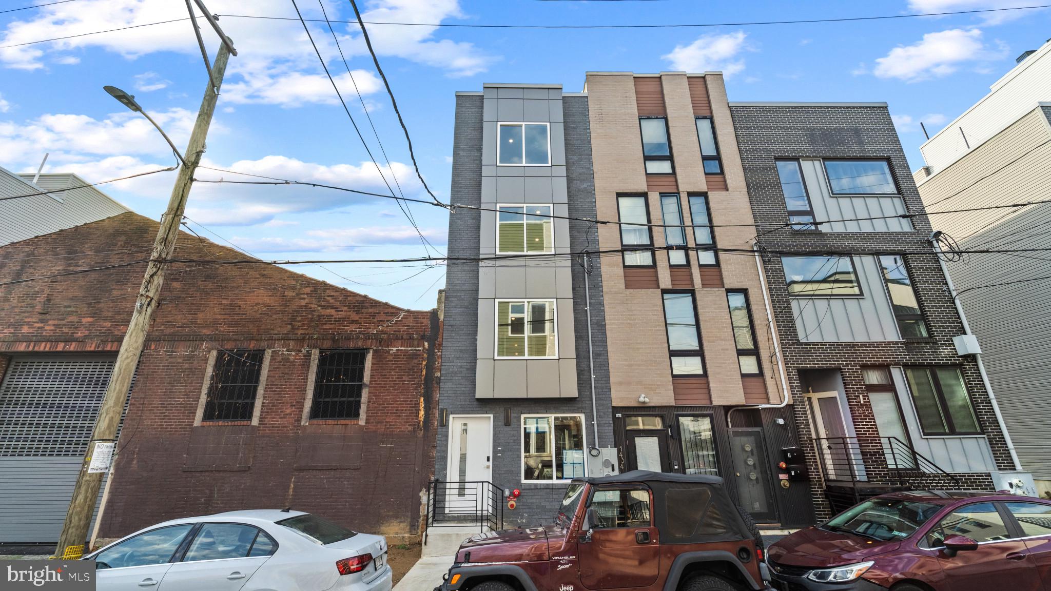 a front view of a residential apartment building with a yard