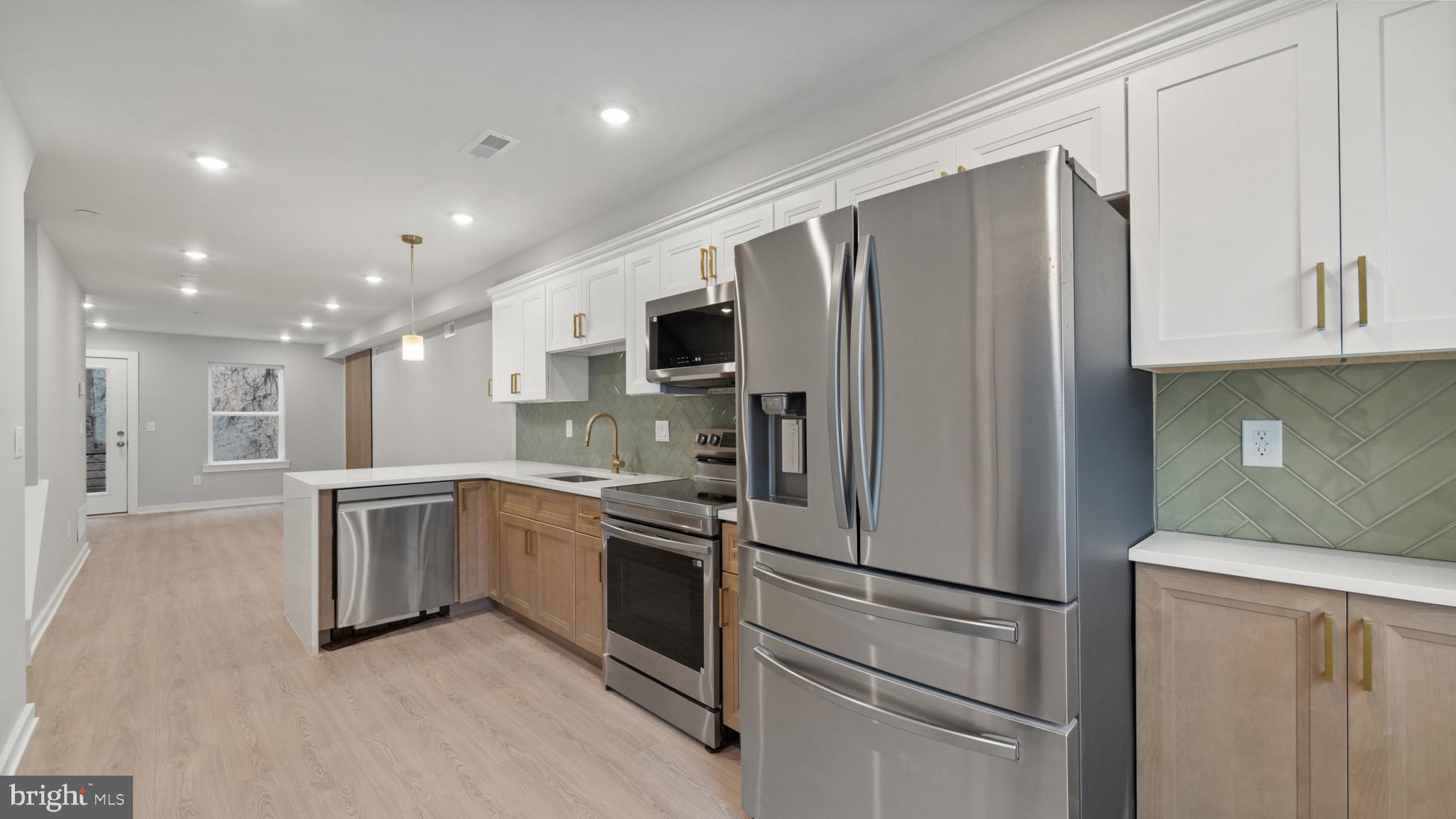 1432 Ogden Street, Unit 1 Philadelphia, PA 19130 - Photo 2 of 17 a kitchen with stainless steel appliances granite countertop a refrigerator a stove and a sink