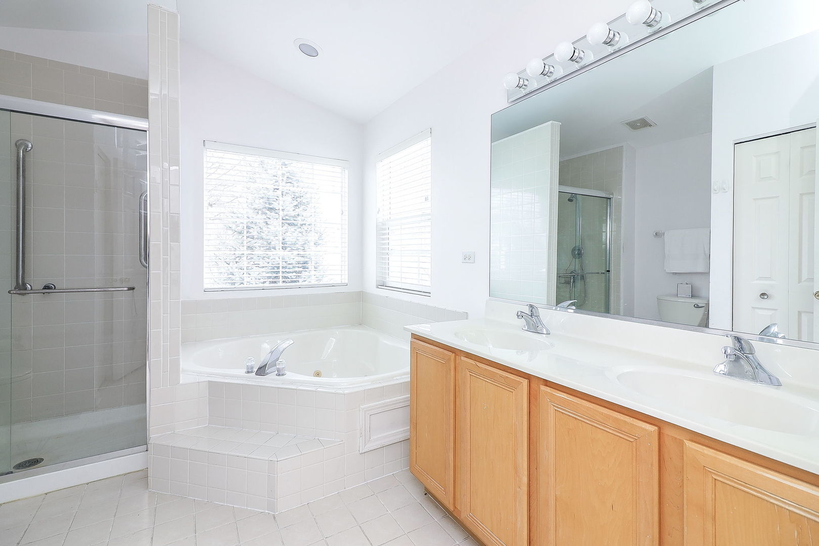1302 Filly Lane Bartlett, IL 60103 - Photo 17 of 29 a bathroom with a double vanity sink bathtub and next to a window