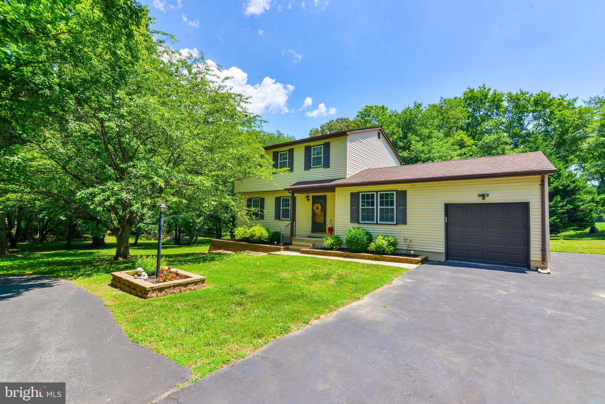 a front view of a house with a yard and green space