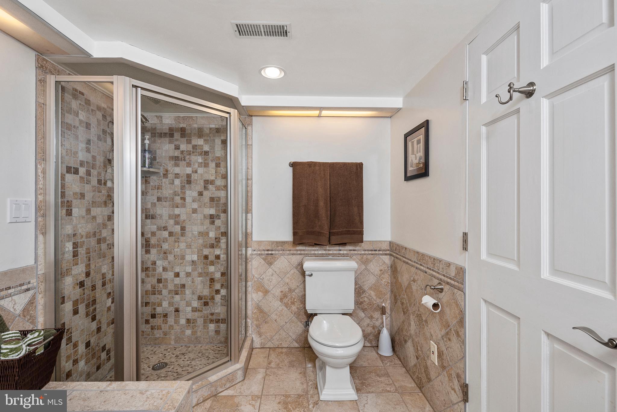 754 Oldfield Point Road Elkton, MD 21921 - Photo 37 of 49 a bathroom with a granite countertop sink a toilet a mirror and shower