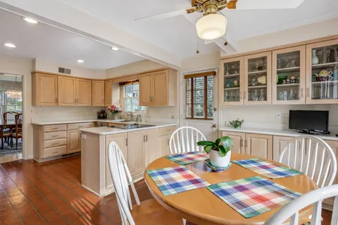 a view of a dining room with furniture a kitchen and chandelier