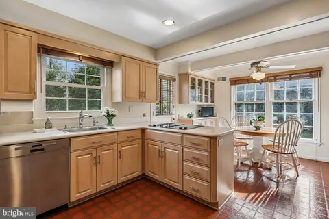 a kitchen with a sink stove and chairs