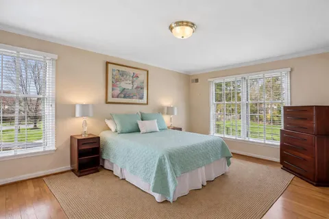 a bedroom with a bed and a dresser next to a window