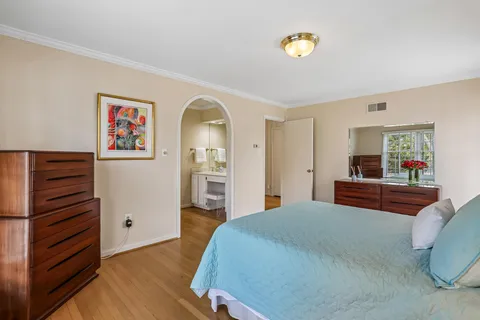 a bedroom with a bed and a painting on the wall