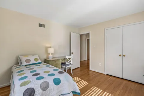 a bedroom with a bed and wooden floor