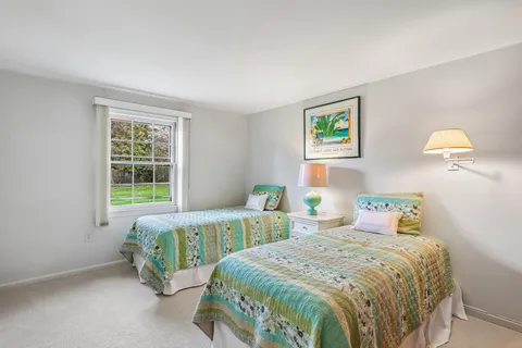 a bedroom with two beds and a window