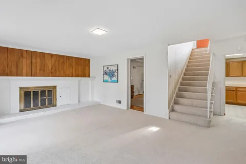 a view of a livingroom with an empty room and stairs