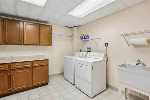 a utility room with cabinets washer and dryer