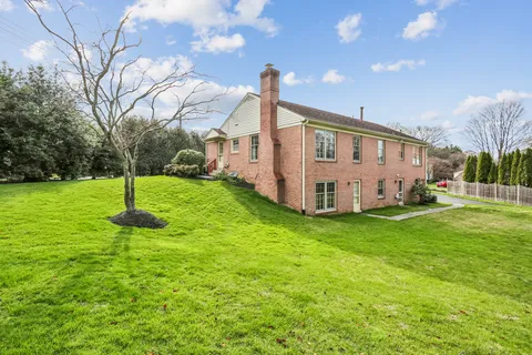 a view of a house with backyard and a tree
