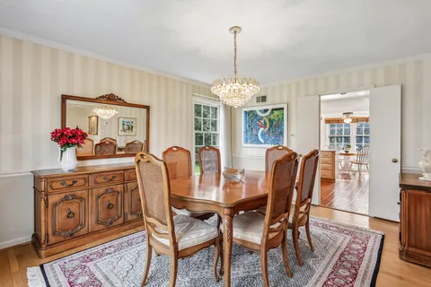a dining room with furniture a chandelier and wooden floor