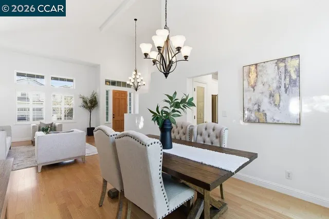 a dining room with furniture potted plants and wooden floor