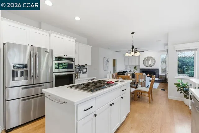 a kitchen with a refrigerator a stove and a table with chairs