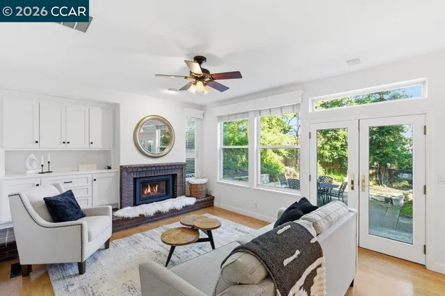 a living room with furniture a fireplace and a large window