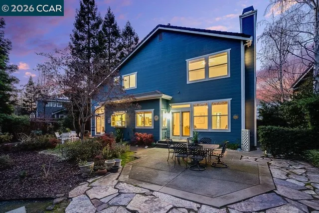 a view of a house with a backyard and sitting area