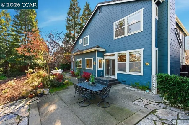 a view of a house with a chairs and table in a patio