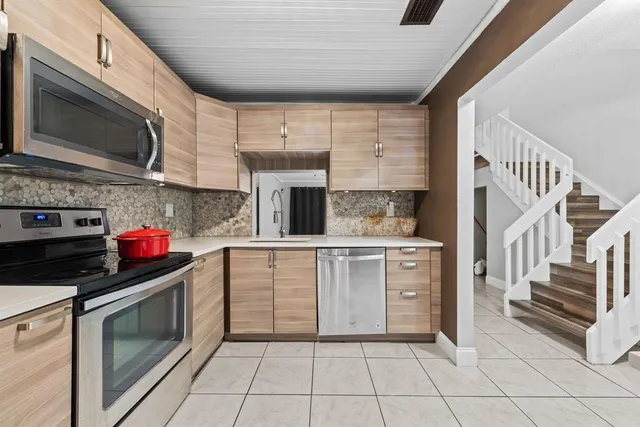 a kitchen with stainless steel appliances a stove microwave and cabinets
