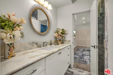a bathroom with a granite countertop sink a mirror and vanity