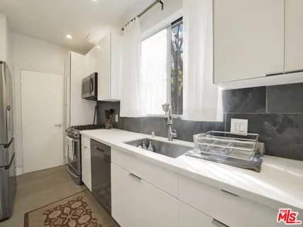 a kitchen with a sink stove and refrigerator