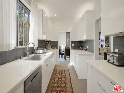 a kitchen with sink a refrigerator and cabinets