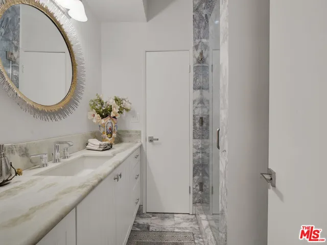 a bathroom with a granite countertop sink and a mirror