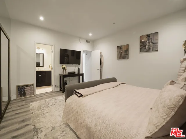 a bedroom with a bed and a flat screen tv