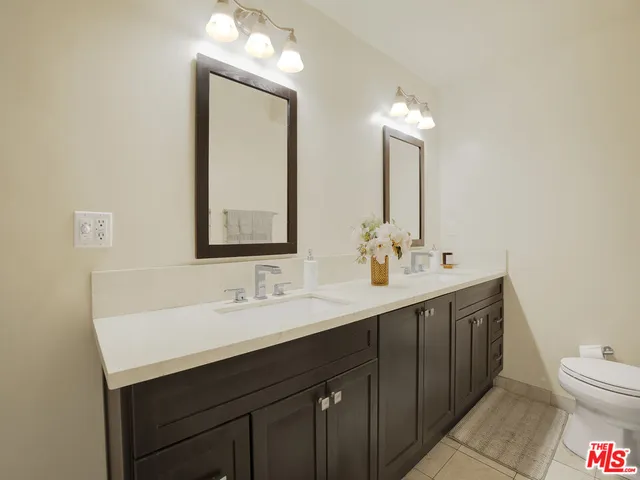 a bathroom with a double vanity sink mirror and toilet