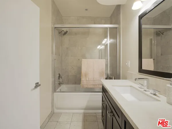 a bathroom with a tub sink and mirror