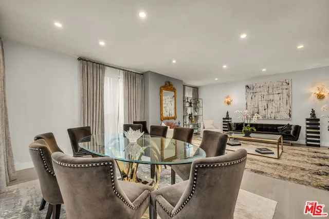 a living room with furniture and a dining table with wooden floor