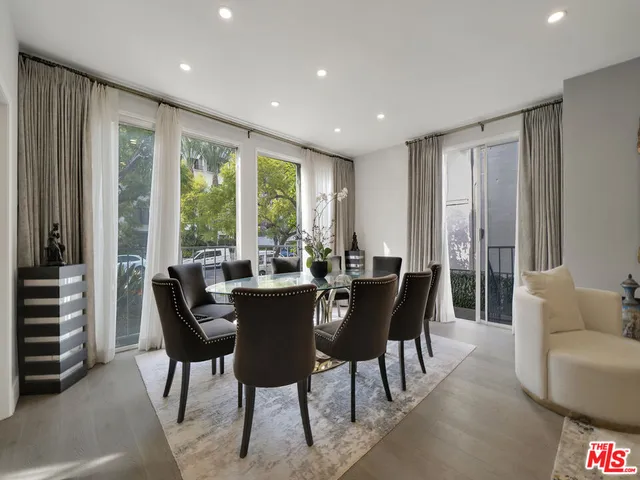 a dining room with furniture a chandelier and wooden floor