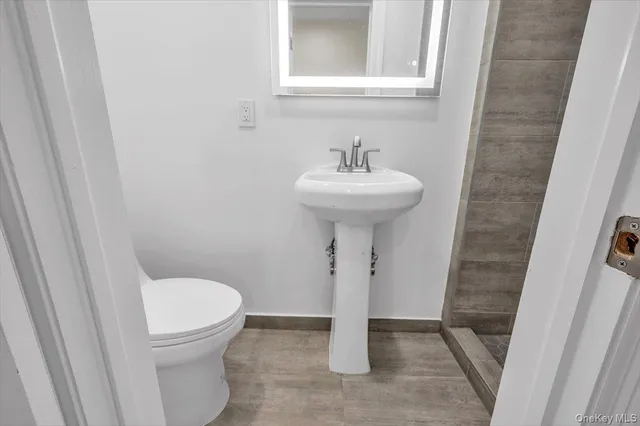 a bathroom with a sink toilet and a mirror