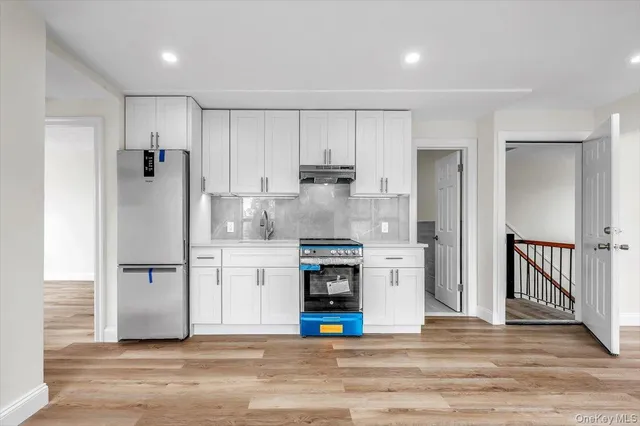 a kitchen with stainless steel appliances granite countertop a refrigerator and a stove top oven
