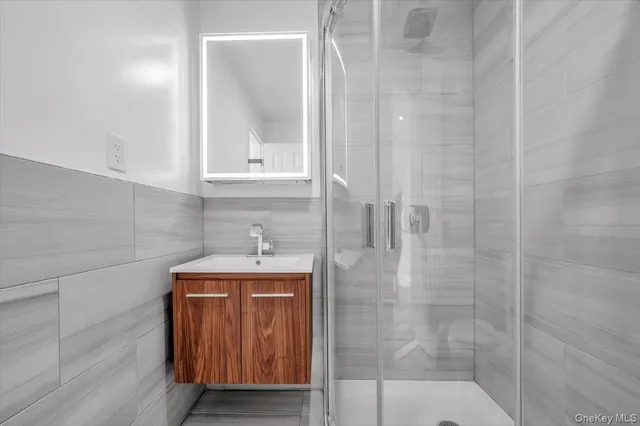 a bathroom with a granite countertop shower a sink and vanity