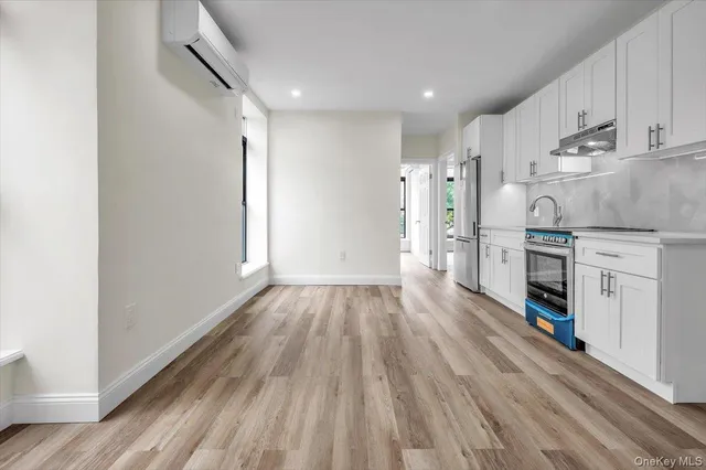a view of a kitchen with wooden floor and electronic appliances