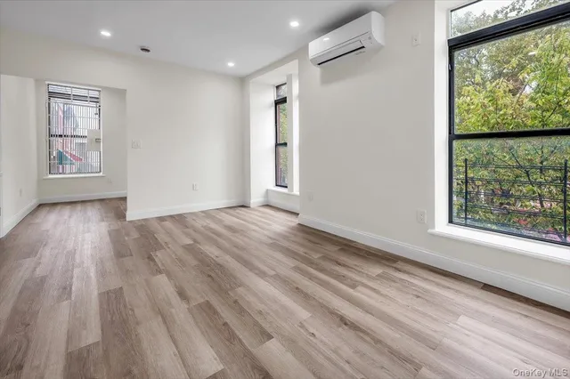 a view of hallway with a large window and wooden floor