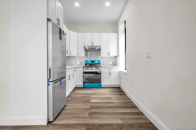 a kitchen with stainless steel appliances granite countertop a refrigerator and a stove top oven