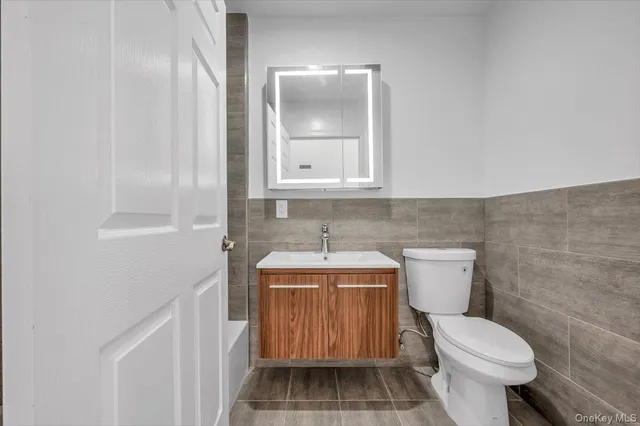 a bathroom with a toilet a sink and mirror