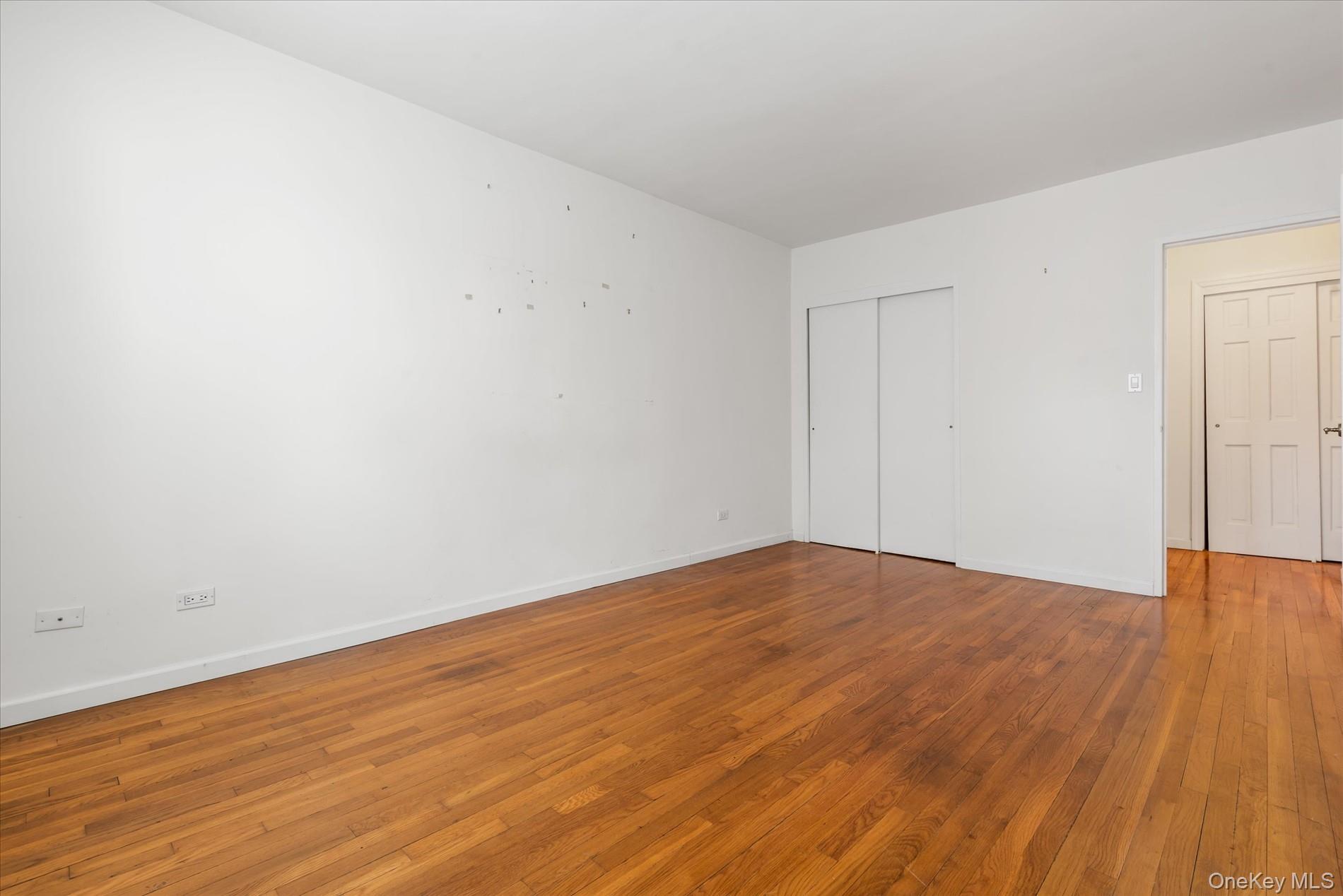 58-th Street West 400th, Unit 5G Manhattan, NY 10019 - Photo 12 of 18 Unfurnished bedroom with a closet, baseboards, and wood-type flooring