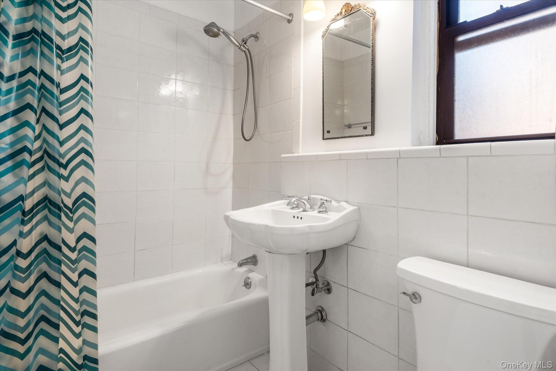 58-th Street West 400th, Unit 5G Manhattan, NY 10019 - Photo 13 of 18 Bathroom with shower / tub combo with curtain, tile walls, and toilet