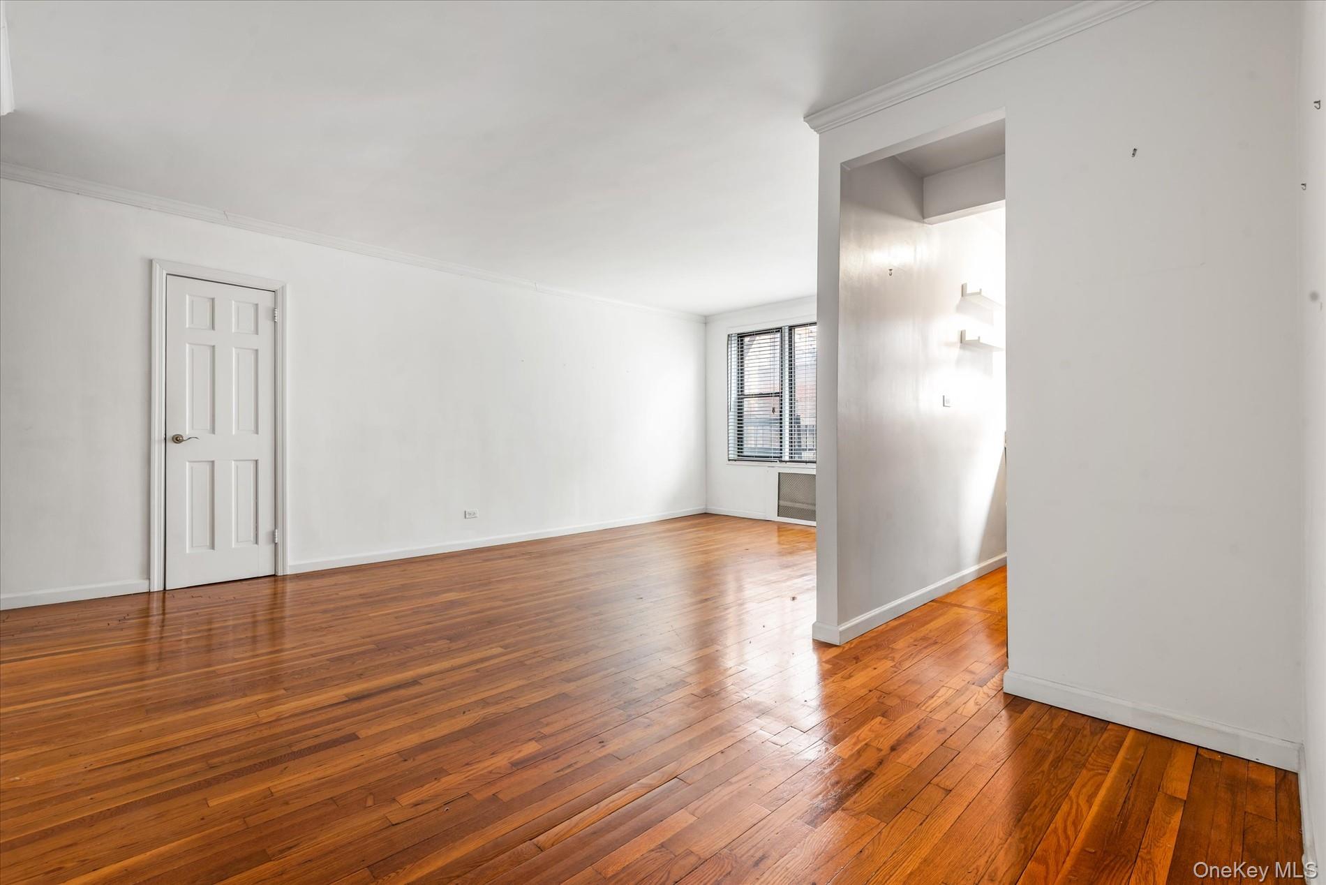 58-th Street West 400th, Unit 5G Manhattan, NY 10019 - Photo 4 of 18 Unfurnished room with hardwood / wood-style floors, crown molding, and baseboards