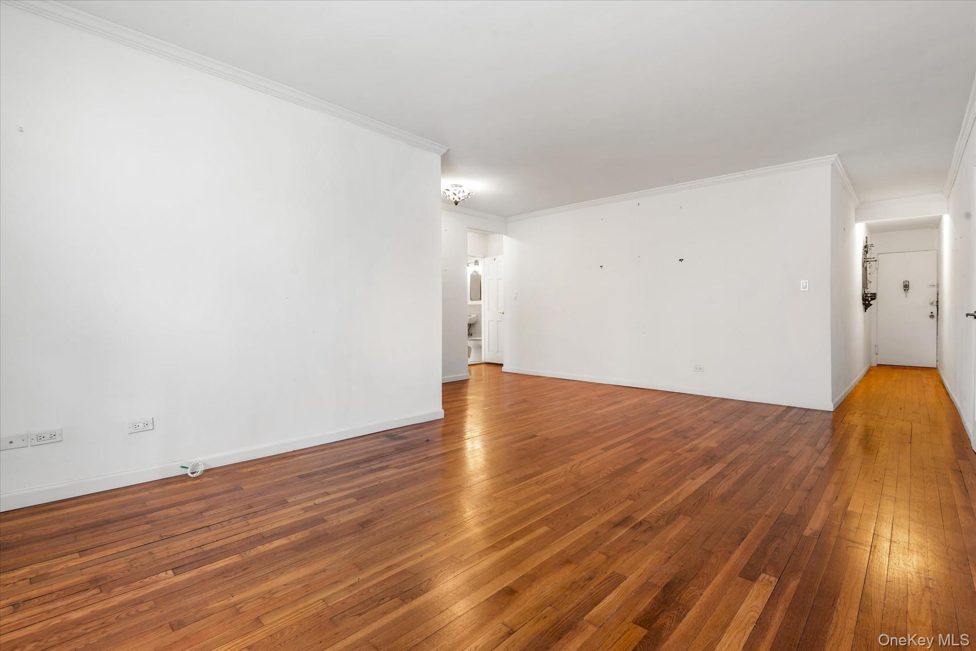 58-th Street West 400th, Unit 5G Manhattan, NY 10019 - Photo 6 of 18 Unfurnished room featuring crown molding, baseboards, and wood-type flooring