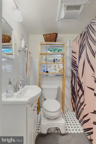 a bathroom with a sink a toilet and shower curtain