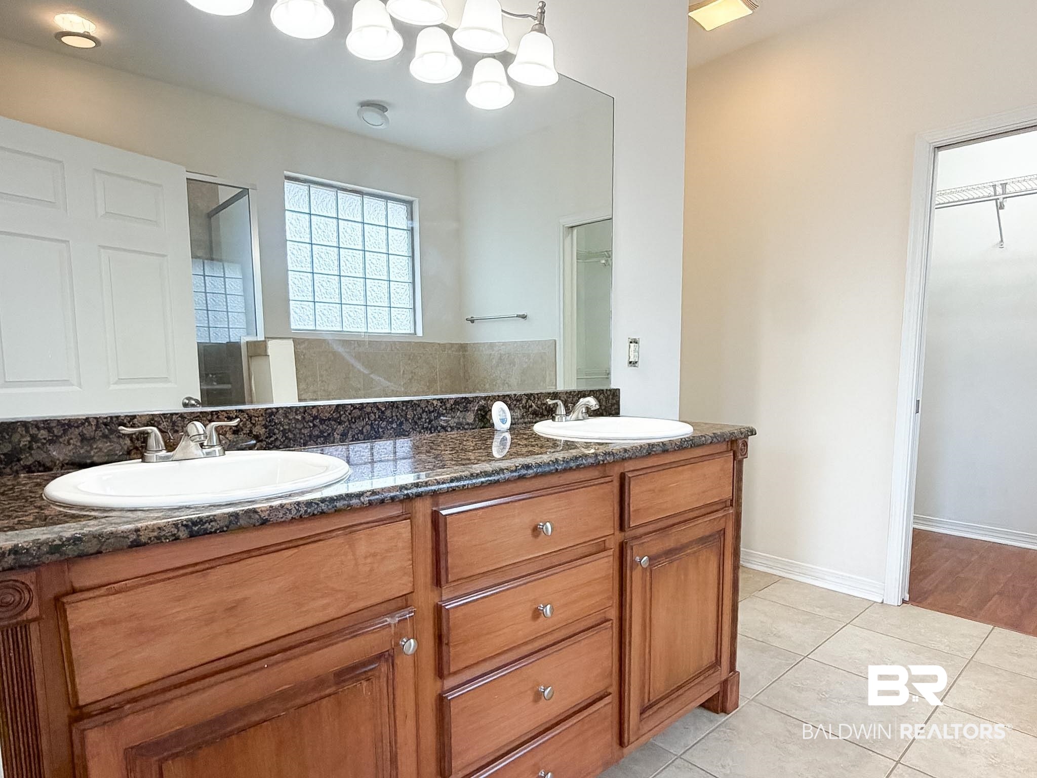 7332 Raintree Lane Gulf Shores, AL 36542 - Photo 11 of 21 Bathroom with double vanity, light tile patterned flooring, and a stall shower