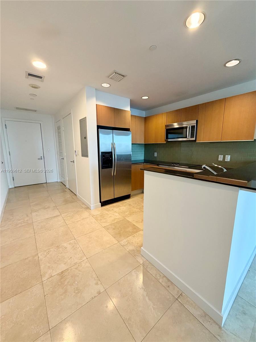 1060 Brickell Avenue, Unit 2113 Miami, FL 33131 - Photo 2 of 52 a kitchen with stainless steel appliances granite countertop a sink and a stove top oven with wooden floor