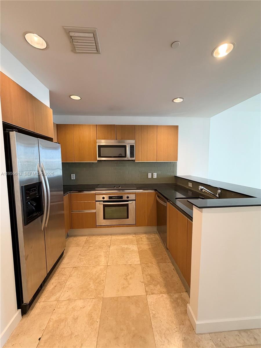 1060 Brickell Avenue, Unit 2113 Miami, FL 33131 - Photo 4 of 52 a kitchen with stainless steel appliances granite countertop a stove a sink and a refrigerator